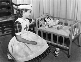 A young girl plays nurse to her Little Lulu doll.