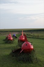 Weird red bugs with shark like appearance march across the plain; Located just off Interstate 90 in the South Dakota Drift Prairie, about 25 miles west of Sioux Falls. Many of the sculptures, in the s...