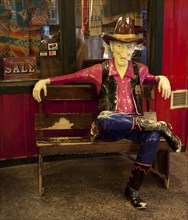 Cowboy sits on bench at Wall Drug in South Dakota 2006