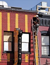 Electrician works on side of building façade 2010