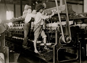 Some boys were so small they had to climb up on the spinning frame to mend the broken threads and put back the empty bobbins 1909