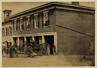 Union soldiers pull a fire engine from a garage designated Petersburg artillery 1865
