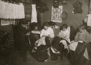 Family of Onofrio Cottone, finishing garments in a terribly run down tenement. 1924