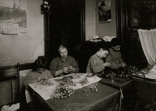 Basso family Making roses in dirty, poorly lighted kitchen.  1912