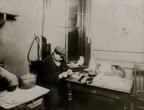 Fifty-five year old man adding a little to income by making feathers.  1912