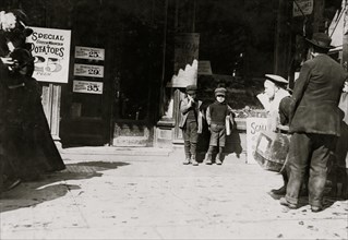 7 year old twins selling newspapers in front of newsstand 1909