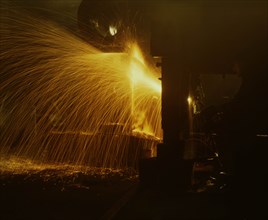 Welder's torch has sparks fly on Locomotive factory Floor 1942