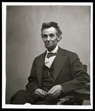 Abraham Lincoln, three-quarter length portrait, seated and holding his spectacles and a pencil 1865