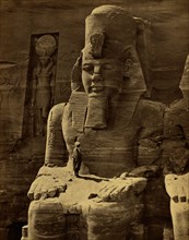View of colossal figure, probably Ramses II, carved into rock that is the Great Temple at Abu Sunbul, Egypt. 1865