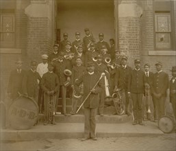 African American band posed on steps to brick building 1899