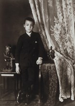 African American boy, full-length portrait, standing, facing front with left hand resting on table 1899