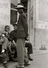 African American boys wait outside of barber shop 1938