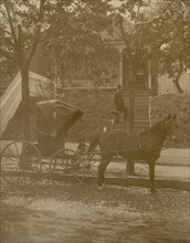 African American doctor carrying small leather bag, standing on steps to residence, horse-drawn carriage in the foreground 1899