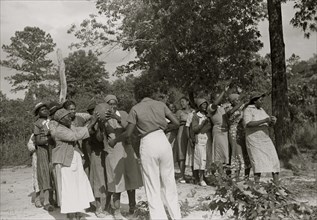 African American entertaining women with line and medicine ball to get exercise and have fun 1939