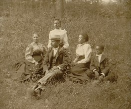 African American family posed for portrait seated on lawn 1899