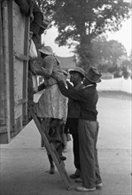 African American Helps a woman on board the migratory worker truck 1938