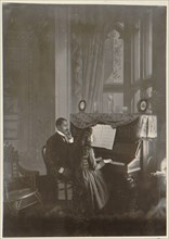 African American man giving piano lesson to young African American woman 1899