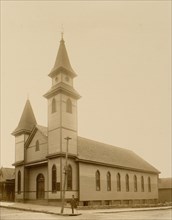 African American man standing on sidewalk in front of church 1899