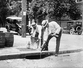 Agents Pouring liquor down a sewer on the Street 1921