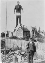 An old man carrying a rifle guards a hanging effigy of Kaiser Wilhelm 1918