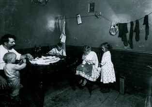 Doing crochet on underwear in dirty kitchen 1912