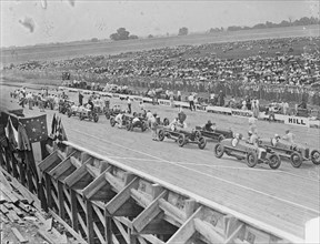 Auto racers at Speedway line up at starting line to begin the race. 1925