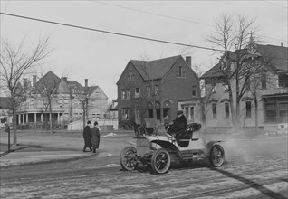 Auto Trundles down city street 1908