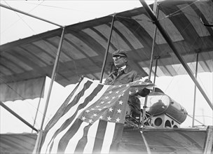 Aviator C.B. Harmon Unfurls Stars and Stripes from his pilot seat on his Biplane.