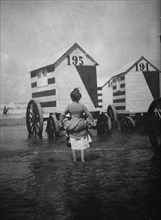 Bathing Booths at Ostend, Belgium; womanbather lifts up her dress 1912