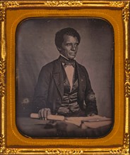 Beverly Page Yates, half-length portrait, facing slightly right, seated at table, holding rolled piece of paper 1857