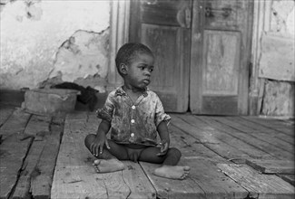 Black child on porch of dilapidated Trepagnier plantation near Norco, Louisiana 1938