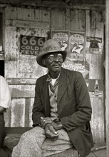 Black on porch of general store near Jeanerette, Louisiana 1938