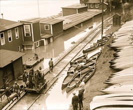 Blackes on train vehicle on the tracks beside the river that is flooding 1924
