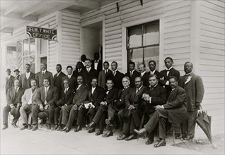 Booker T. Washington seated with group of men  1915