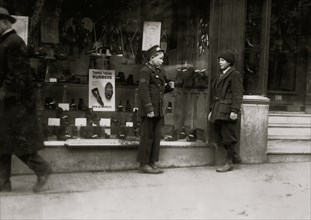 Boston delivery by in front of a retail shop speaks to a friend 1917