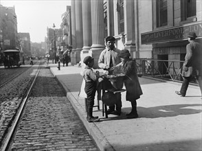 Boys buy peanuts from Street Vendor of 42nd street. NYC 1903