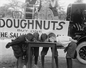 Boys Chow Down on a Table in a Donut Eating Contest 1922
