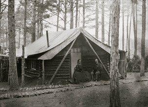Brandy Station, Virginia. Col. John R. Coxe, A.C.S., and lady seated before his log-cabin winter quarters at Army of the Potomac headquarters 1864