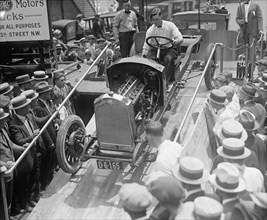 Buick Motor car is driven off a flat bed using a ramp. 1924
