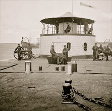 Charleston Harbor, S.C. Deck and officers of U.S.S. monitor Catskill; Lt. Comdr. Edward Barrett seated on the turret 1865