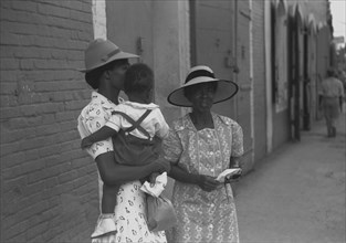 Mother and children waiting on the main street on Sunday 1942