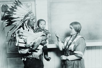 Chief Fish Wolf Robe in Native Dress and War bonnet, his child and wife