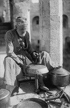 Coppersmith Hammers a Pot into shape 1930