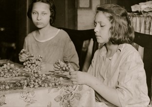 Cottage Industry shows young girls stringing material in piecework done at home. 1924