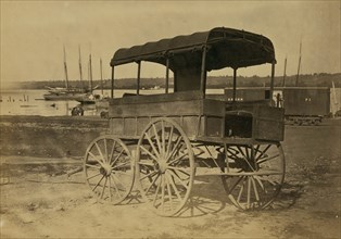 Covered wagon with side curtains rolled up at a military facility 1863