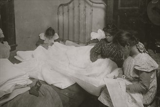 Family cutting cut embroidery in tiny crowded bed-room 1912