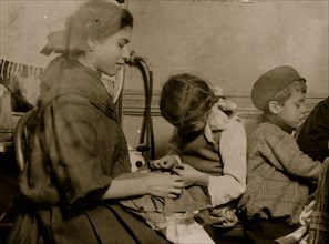Italian Family works on garments in their tenement apartment 1911