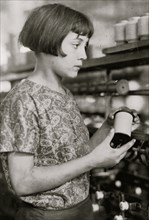 Girl holds a spool of silk thread 1924