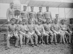 Graduating Class of Japanese Aviators in Uniform with Ceremonial Swords seated in front of Airplane