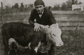 Harry Harper, one of the 4 H Club boys with his registered calf.  1921